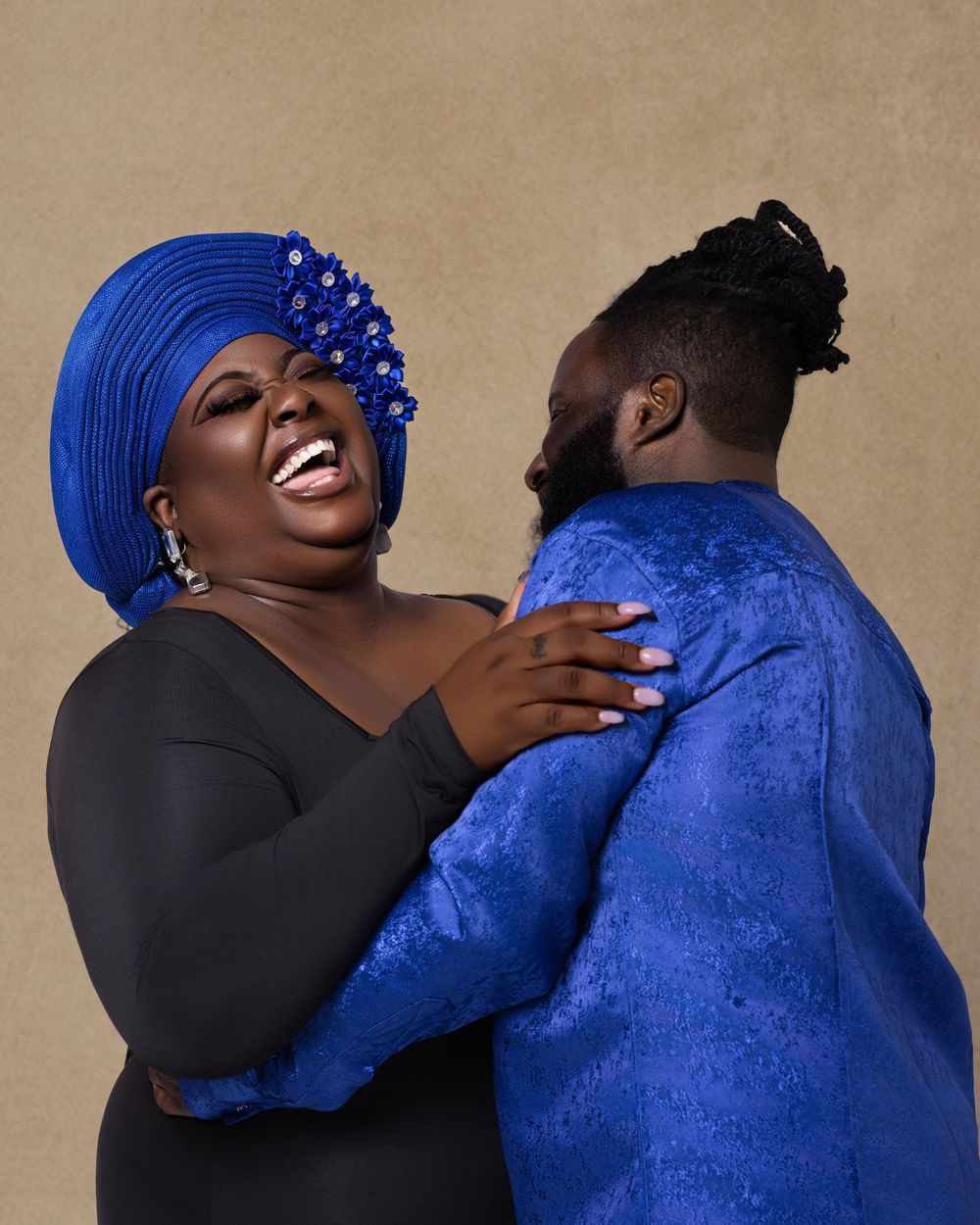Couple in coordinating royal blue outfits sharing joyful moment.