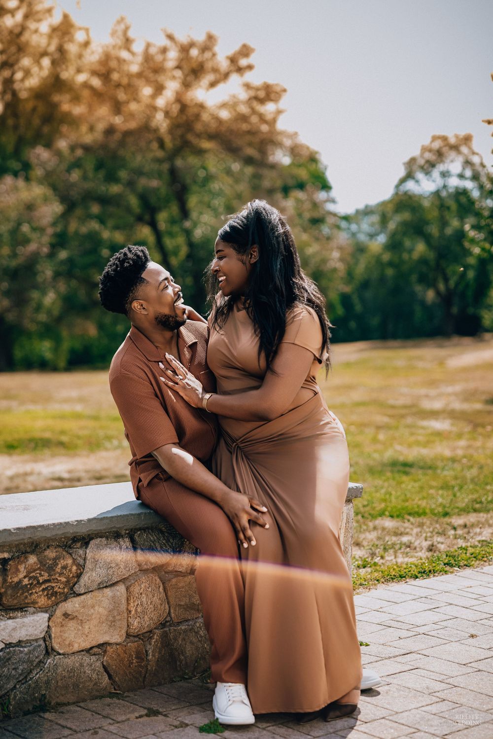 A mother and child share playful moments together on a stone path in a park.