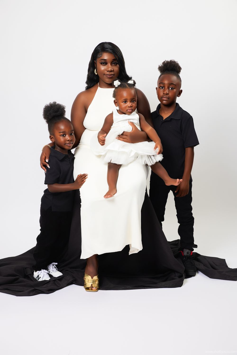 Modern family studio portrait with striking black and white color scheme against white background.