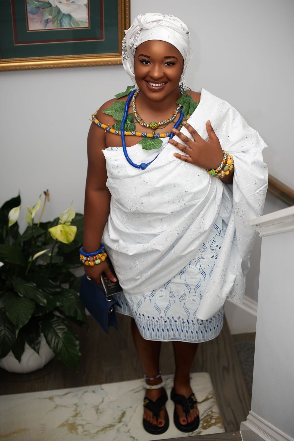 Traditional white dress styled with colorful beaded accessories and head wrap.