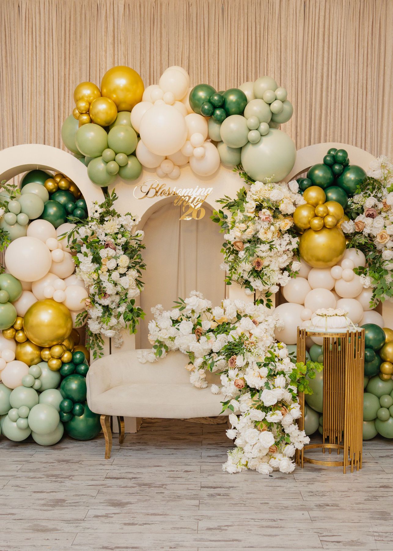 Elegant wedding reception venue with white chiavari chairs, round tables, and tall floral centerpieces in white and green.