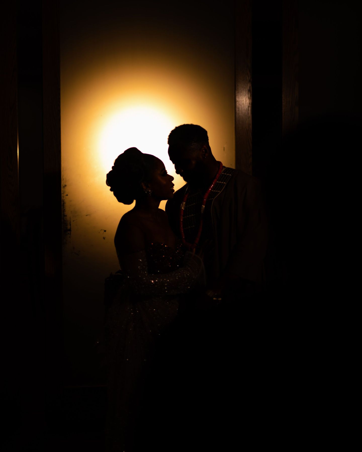 Silhouette of a couple against a glowing light in the dark